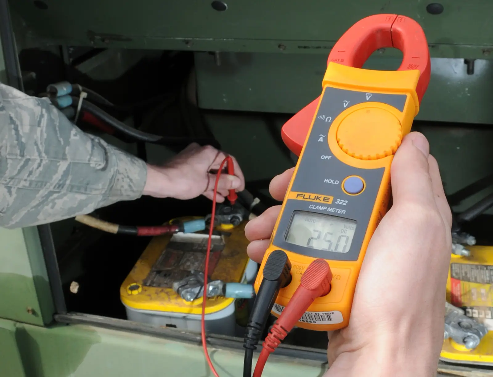 Electrician checking voltage with a clamp meter